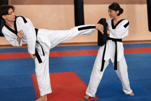 Tatami üzerinde taekwondo antrenmanı yapan iki sporcu